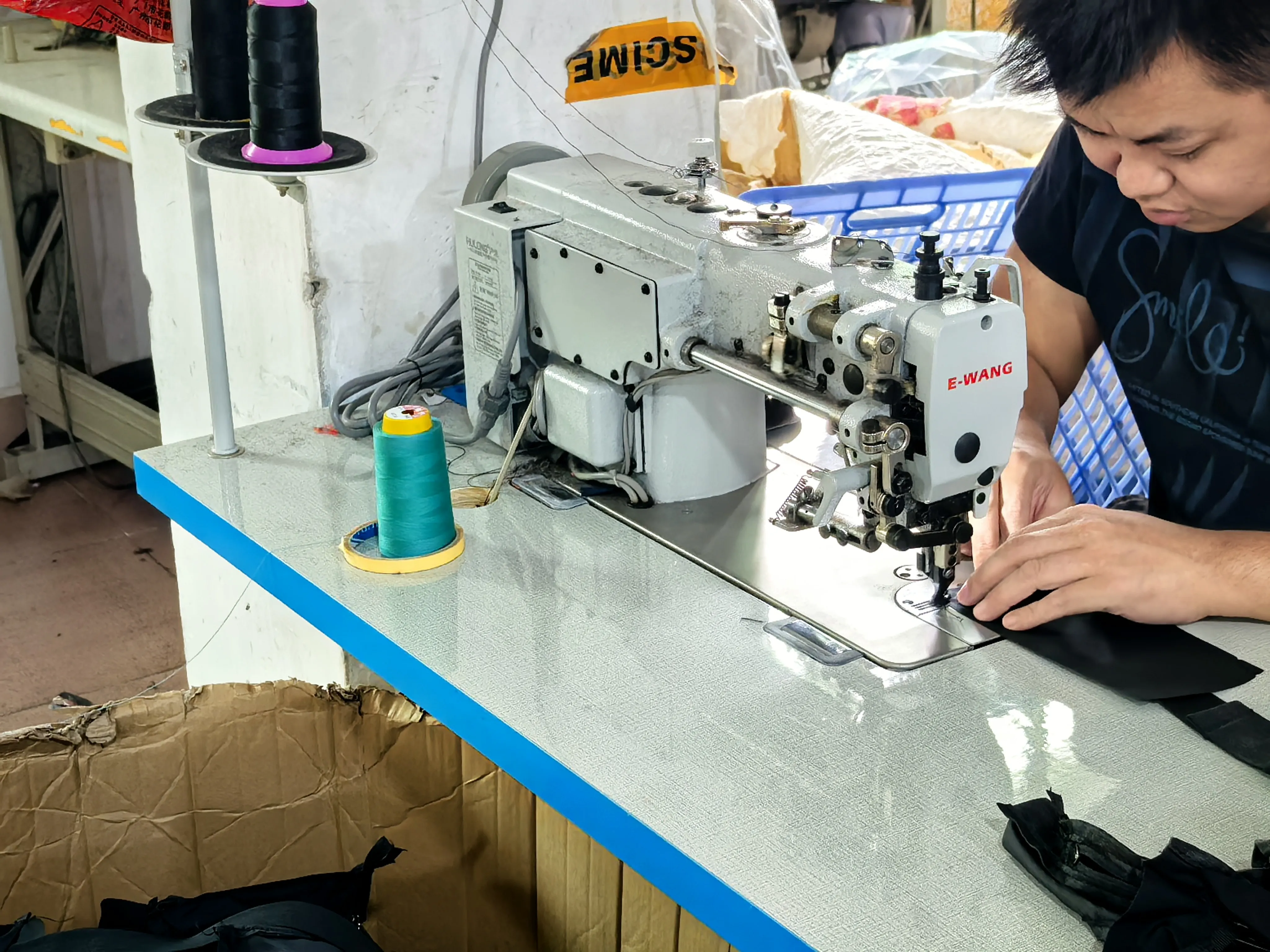 GZ Dreamway technician operating an E-WANG heavy-duty sewing machine for tote bag pocket stitching