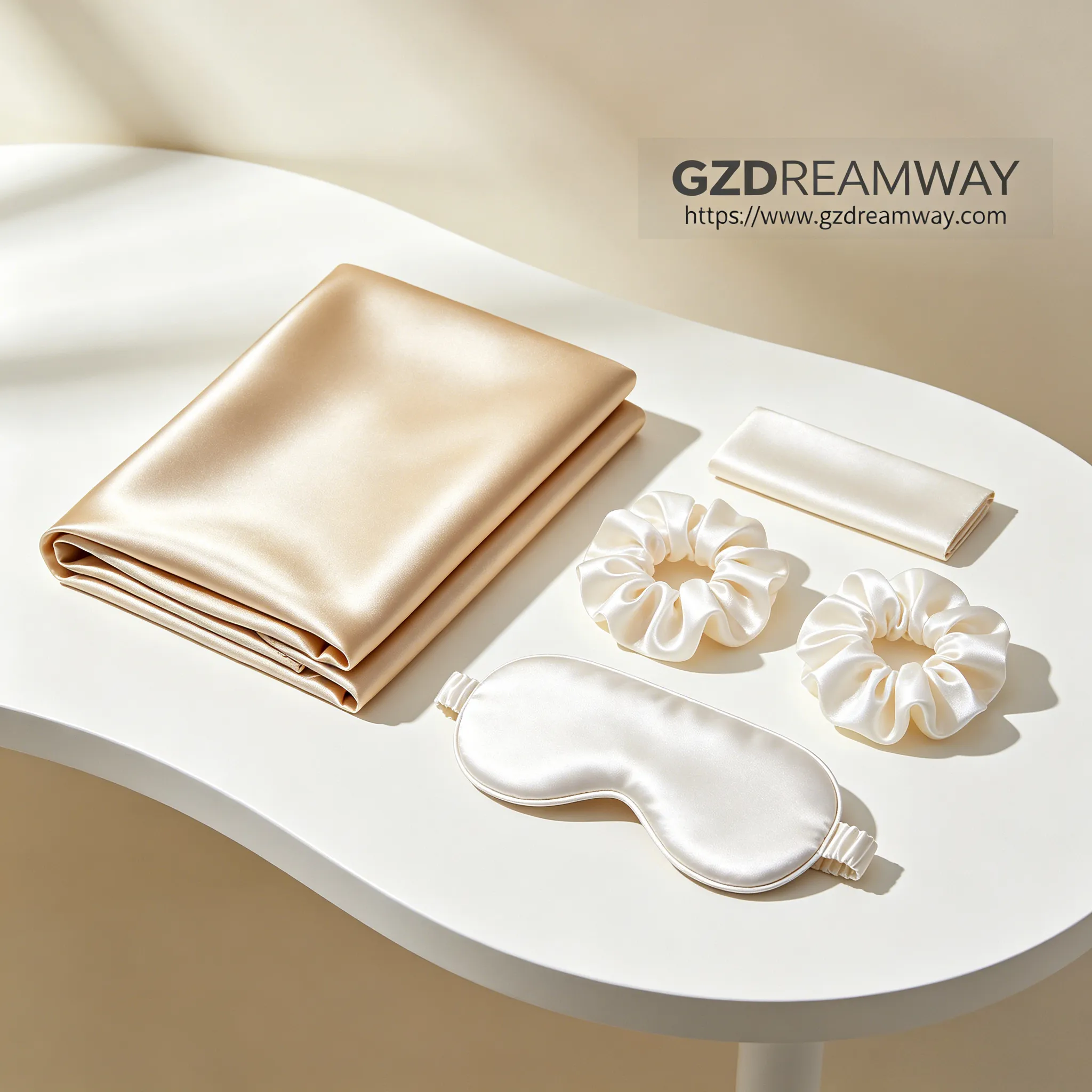 Modern white platform displaying champagne gold 22mm silk pillowcase with two pearl white silk scrunchies and matching silk eye mask